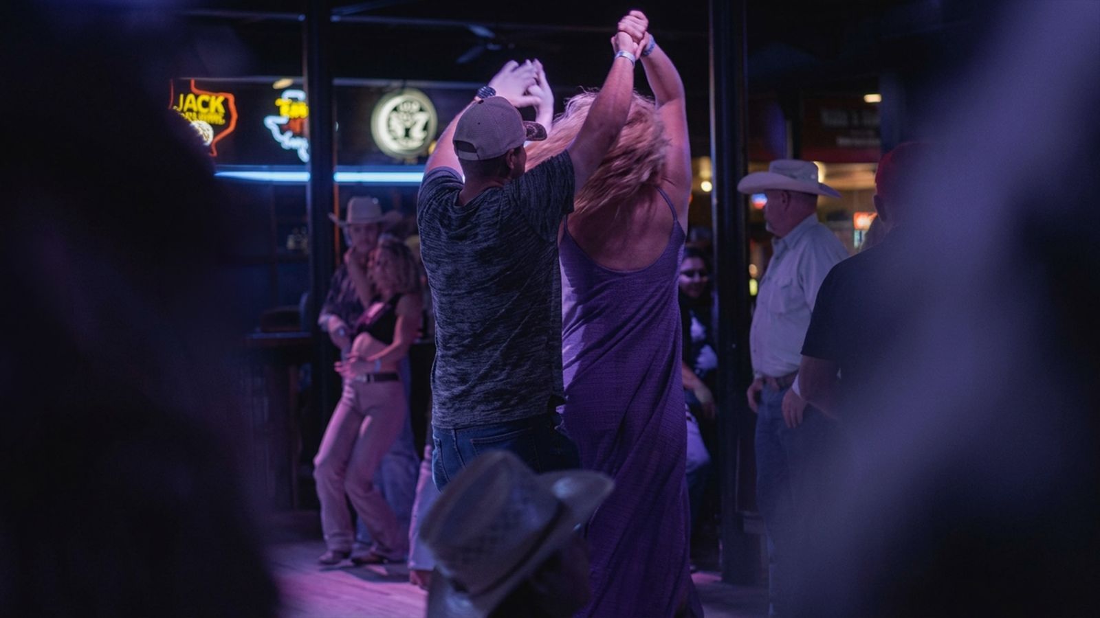 A couple dancing under the neon signs at Rodeo Exchange